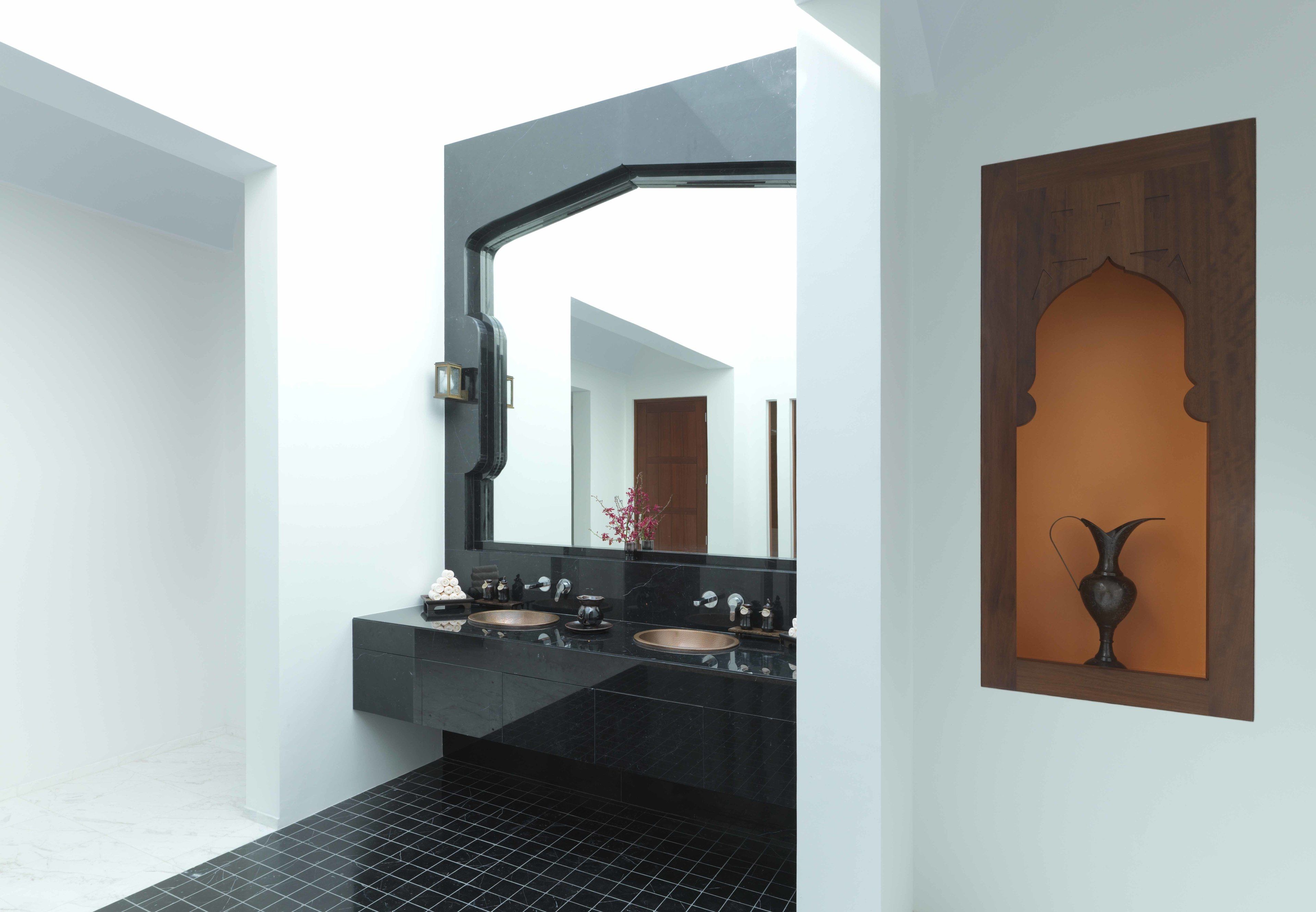 A modern bathroom with two sinks, a large mirror, and a decorative wooden panel.