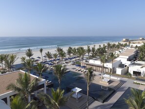 A resort with a pool area, beach access, and palm trees. - Al Baleed Resort Salalah by Anantara (Salalah)