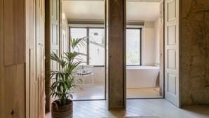 A spacious room with a large window, a bathtub, and a potted plant. - Armazém Luxury Housing (Porto)