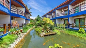 A hotel with a central water feature, surrounded by lush greenery and multiple balconies. - Sueds Plaza (Porto Seguro)
