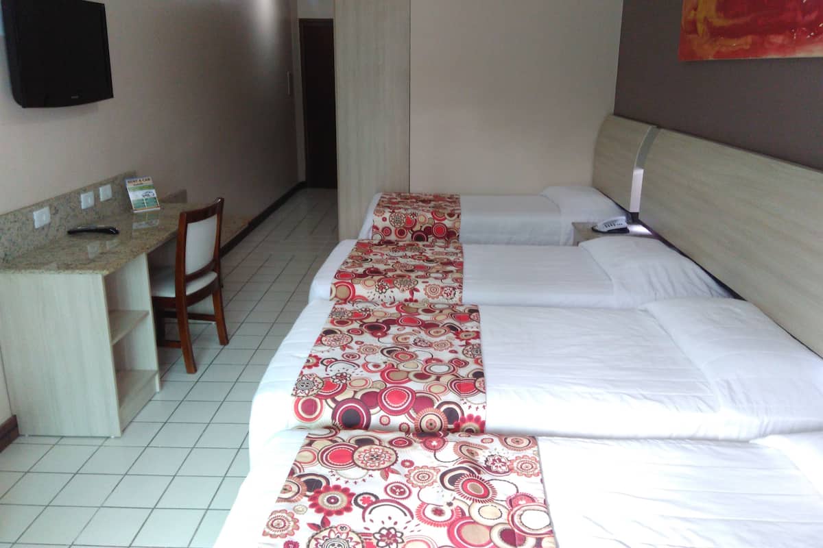 A hotel room with a bed, a desk, and a chair.