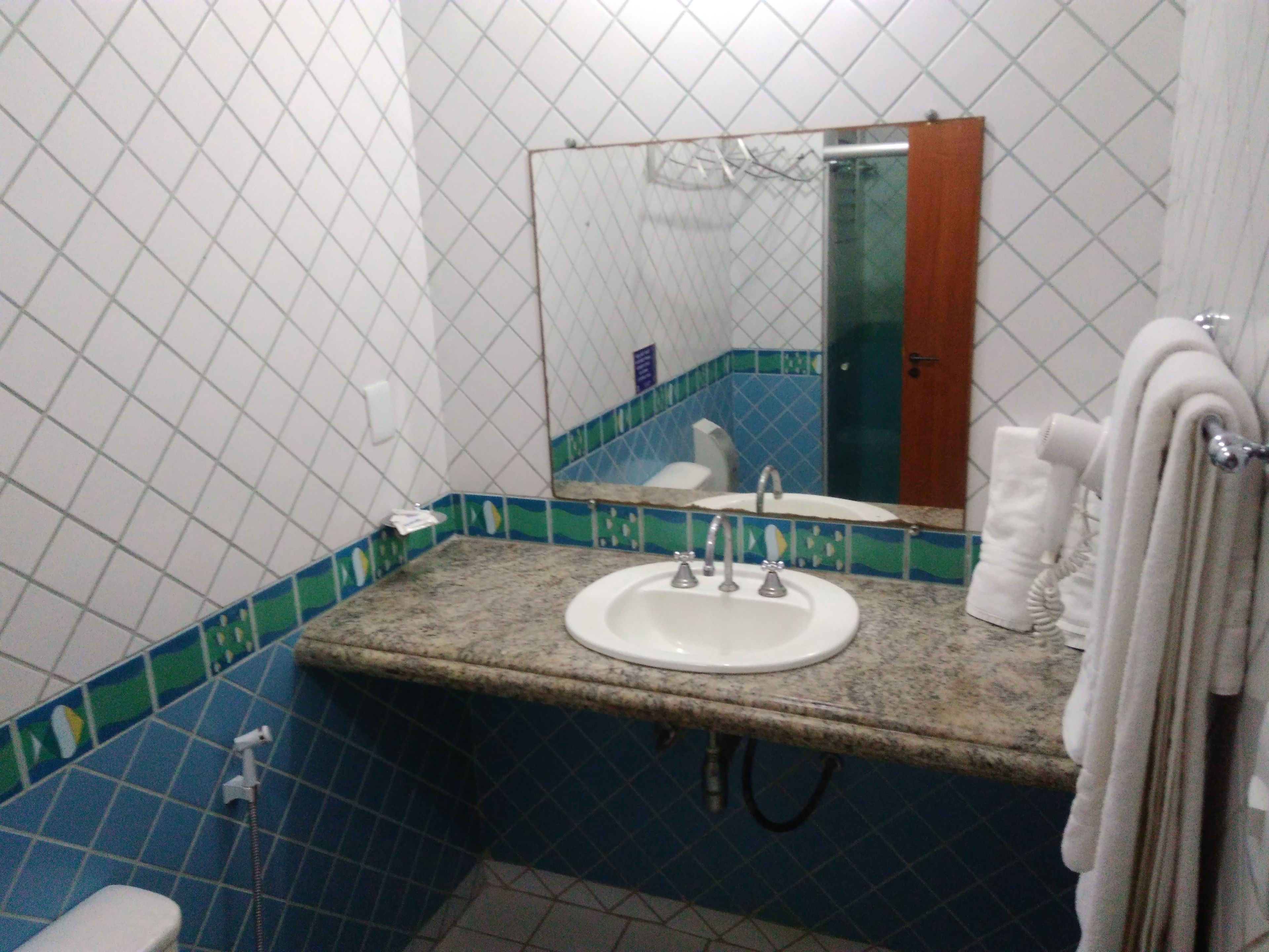 A bathroom with a sink, mirror, and towel rack.