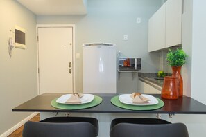 A compact kitchen with a refrigerator, microwave, and a potted plant. - Rio Habitat Almirante (Rio de Janeiro)