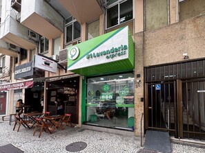 Une devanture de magasin avec un auvent vert, une enseigne indiquant qu’il s’agit d’un restaurant et une entrée bien visible.