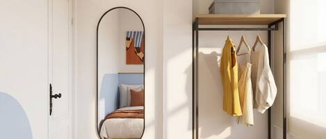 A bedroom with a bed, a wardrobe, a mirror, and a door.