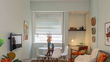 Cocina compacta con comedor, ventilador de techo y ventana con persianas.