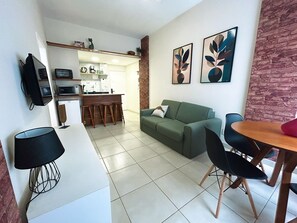 A modern living space with a kitchen, dining area, and a green sofa. - Rio Habitat Almirante (Rio de Janeiro)