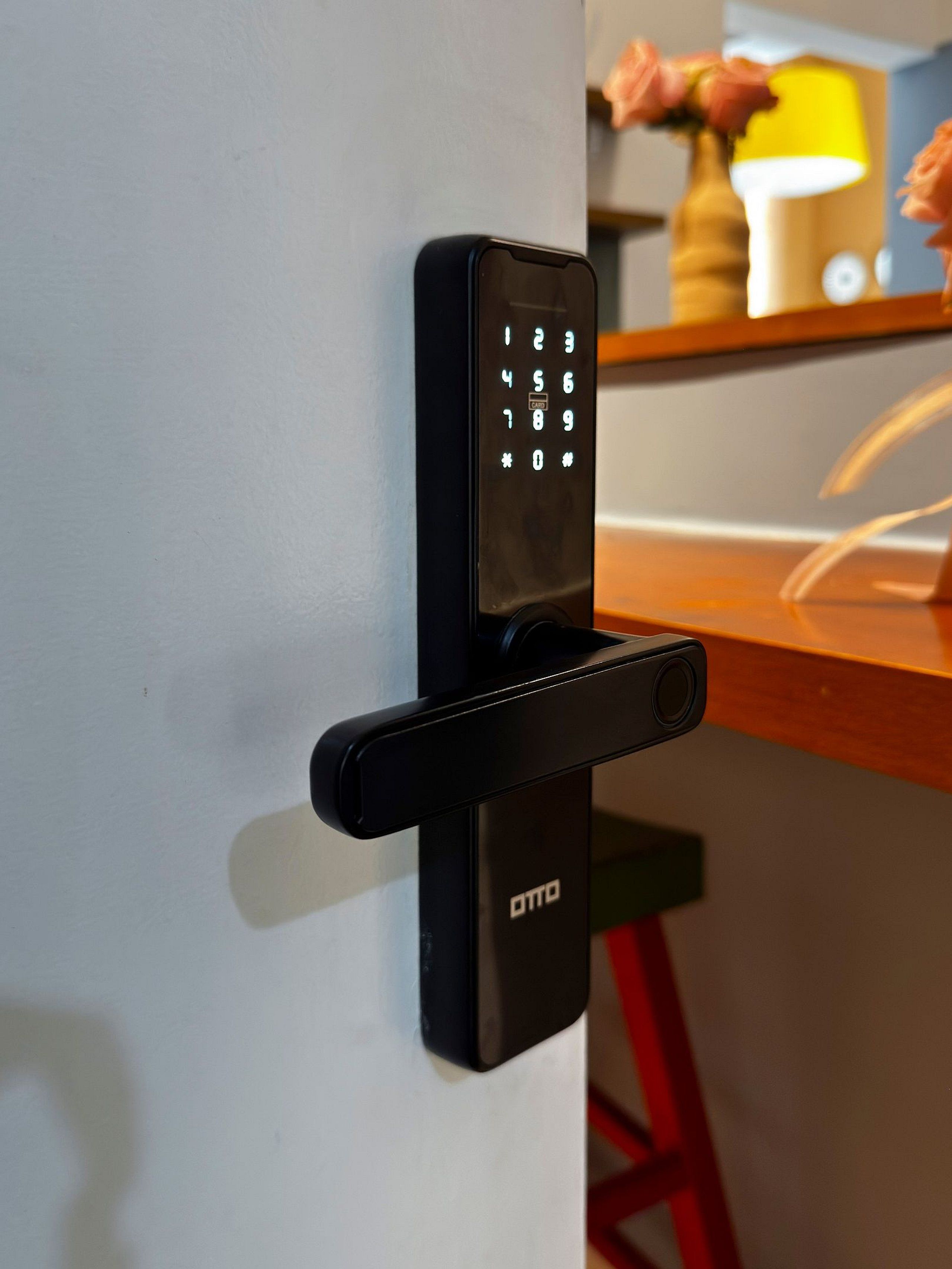 A modern door lock with a keypad, mounted on a white door.