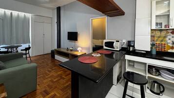 A compact living space with a kitchenette, a dining area, and a seating area.