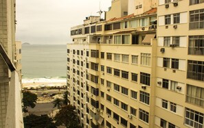 A high-rise building with multiple balconies overlooking a beach and ocean. - Rio Habitat Almirante (Rio de Janeiro)