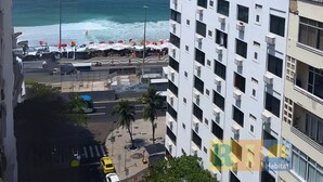 A high-rise building with multiple balconies overlooking a beach and ocean. - Rio Habitat Almirante (Rio de Janeiro)