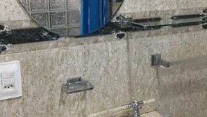 A bathroom with a round mirror, a white sink, a towel rack, and a shower curtain. - Rio Habitat Posto 3 Copacabana (Rio de Janeiro)