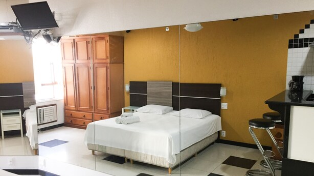 A hotel room with a bed, a wardrobe, a kitchenette, and a bathroom. - Rio Habitat Posto 3 Copacabana (Rio de Janeiro)