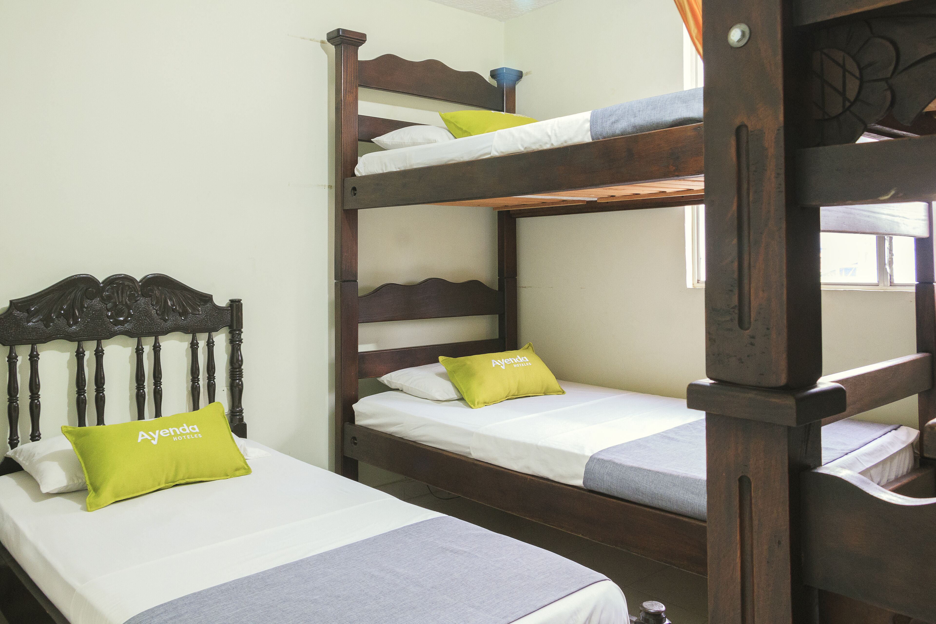 Habitación con literas, dos camas, cada una con almohada y manta.