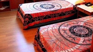 Quarto com duas camas, uma mesa e uma cadeira.