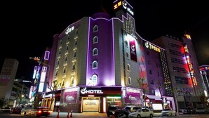 A multi-story hotel with illuminated signage and a prominent 'HOTEL' sign on the facade.