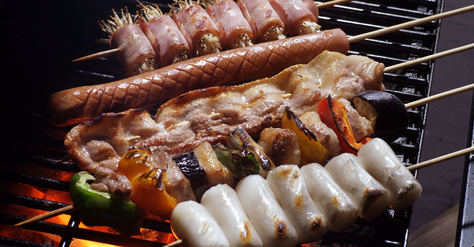 Fleisch und Gemüse werden auf einem Grill gegrillt.