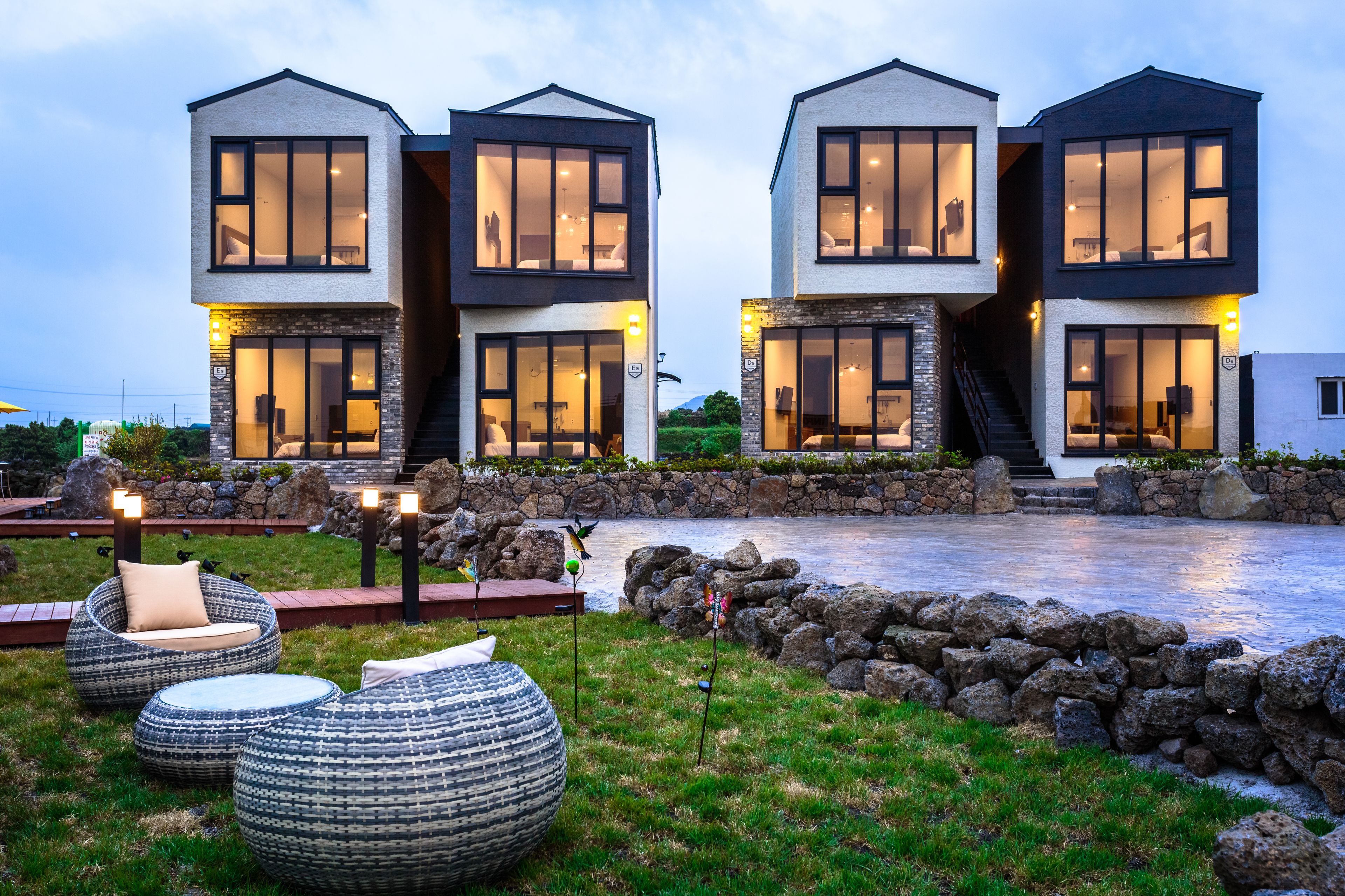 A modern two-story house with large windows and a stone facade.