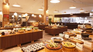 A buffet area with multiple food stations and a kitchen in the background. - Shintamagawa Onsen (Senboku)