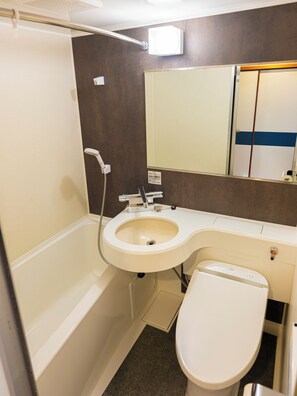A bathroom with a bathtub, a sink, a toilet, a mirror, and a showerhead. - Hifumi Ryokan (Kyoto)