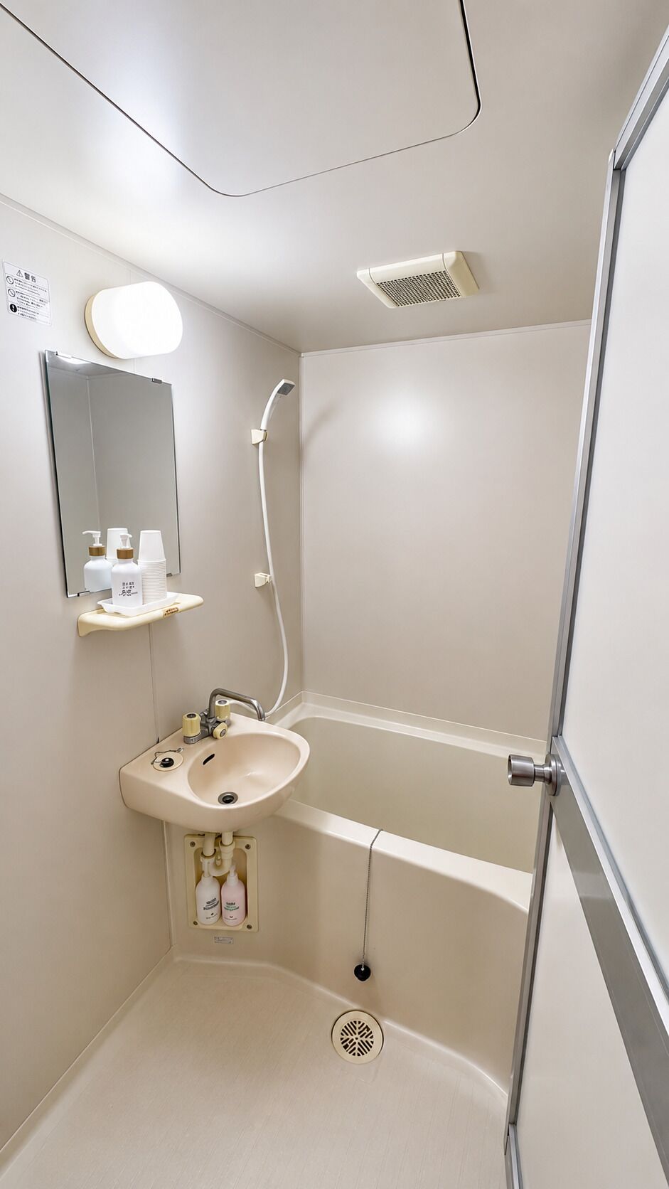 A bathroom with a sink, mirror, shower, and toilet.