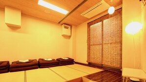 A room with tatami mats, a low wooden table, and a traditional sliding door. - Osaka Guesthouse Nest - Hostel (Osaka)