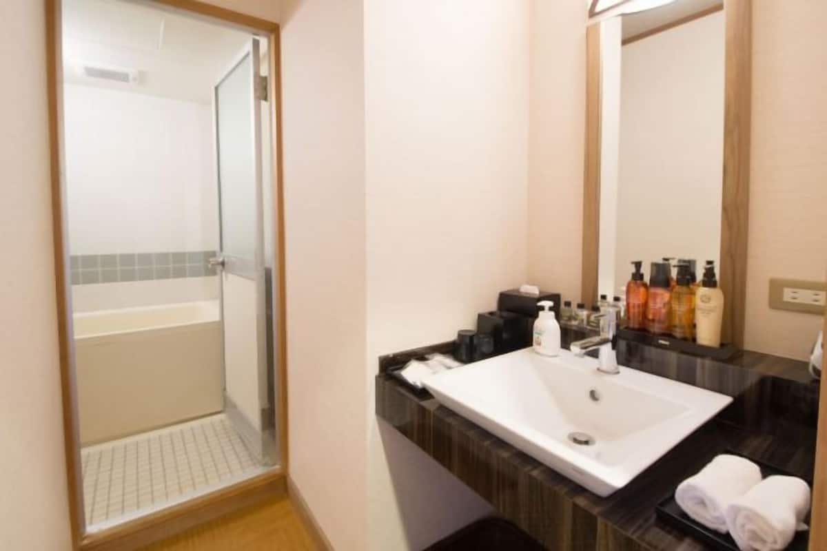 Badkamer | Een bad/douchecombinatie, een diep bad, designer toiletartikelen