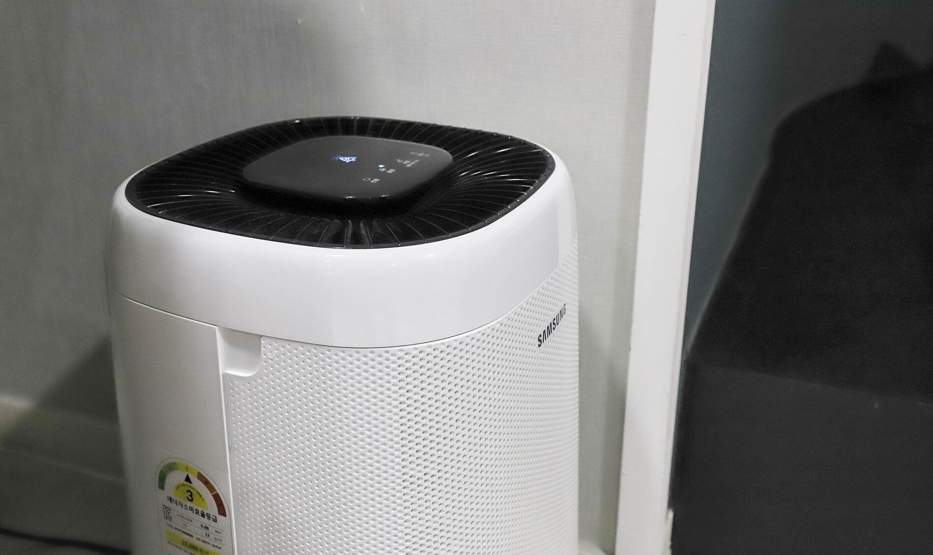 Purificador de aire blanco con pantalla digital y parte superior ventilada.
