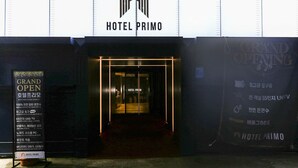 L'ingresso dell'Hotel Primo con un cartello che indica l'inaugurazione.