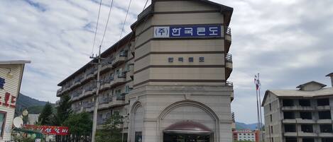 A multi-story hotel with a prominent entrance and a sign in a foreign language.