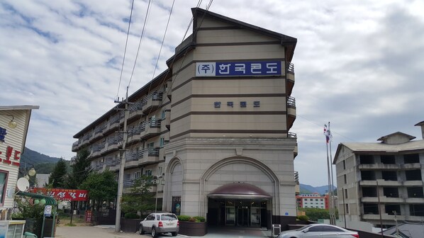 Un hotel de varios pisos con una entrada destacada y un letrero en idioma extranjero.