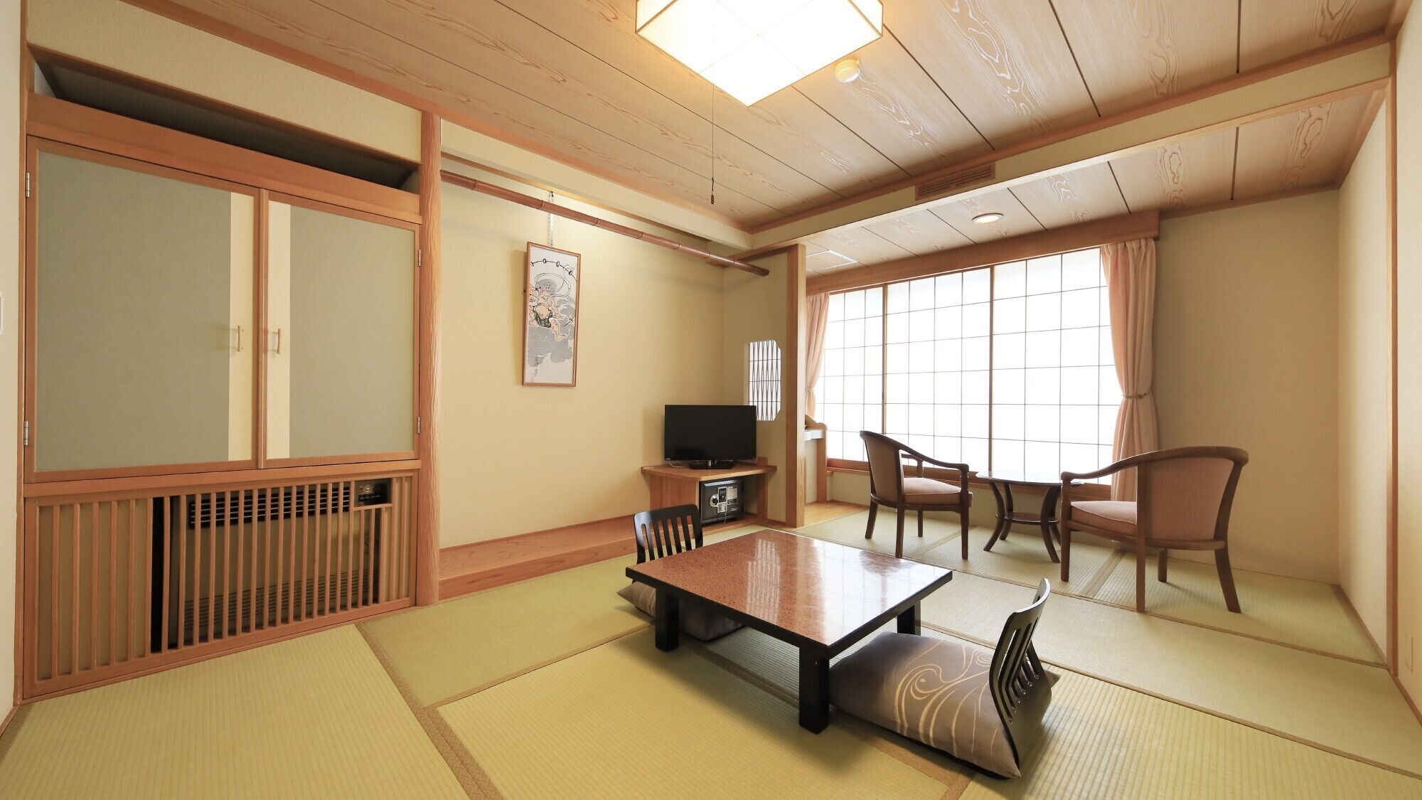 Perinteinen japanilainen huone, jossa on tatamimatto, matala pöytä, tuolit, televisio ja liukuvat ovet.