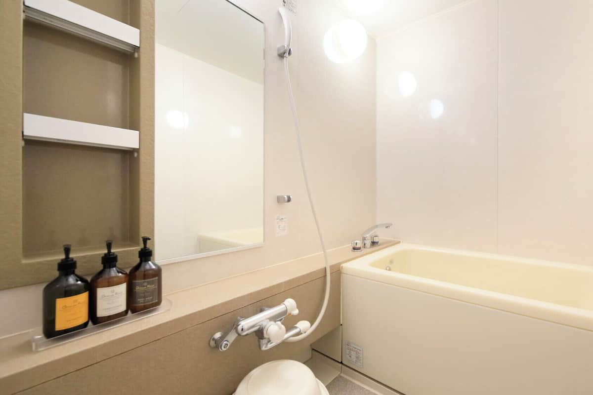 Un baño con bañera, inodoro, lavabo y espejo.