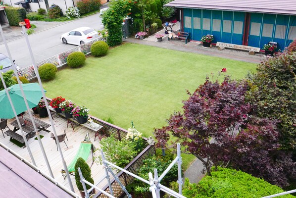 A well-maintained lawn with a wooden deck and outdoor seating area.