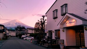 A building with a sign reading "K's House" and a view of a mountain in the background.