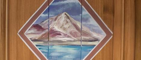 A wooden door with a painted mountain scene and the number A6.