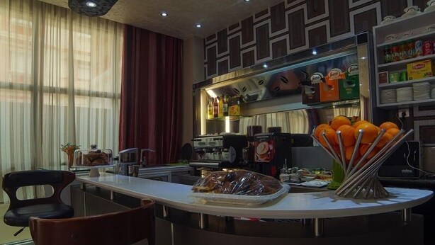 Een moderne keuken met een centraal eiland, een bar en diverse keukenapparaten.