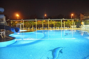 Relax by the pool, where lounge chairs invite you to unwind and a water slide adds to the fun.