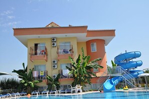Experience the unique architecture and tropical ambiance of this hotel, featuring a spacious balcony area and a refreshing pool with lounge chairs.