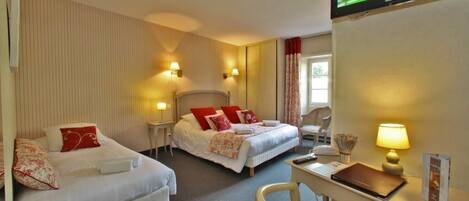 Quarto de hotel com duas camas, uma escrivaninha, televisão e janela com cortinas.