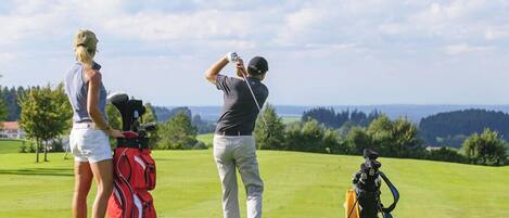 Un campo de golf con una vista despejada del horizonte, un bolso de golf y un palo de golf.