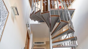 A spiral staircase with metal railings and wooden steps leading to an upper floor. - Hotel Conte Ruggero (Serra San Bruno)