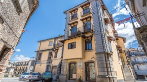 A hotel with a stone facade, multiple balconies, and a sign indicating it is a hotel. - Hotel Conte Ruggero (Serra San Bruno)