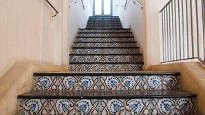 A staircase with patterned tiles leading to a doorway. - Palazzo Conti Camere & Suite (Scicli)