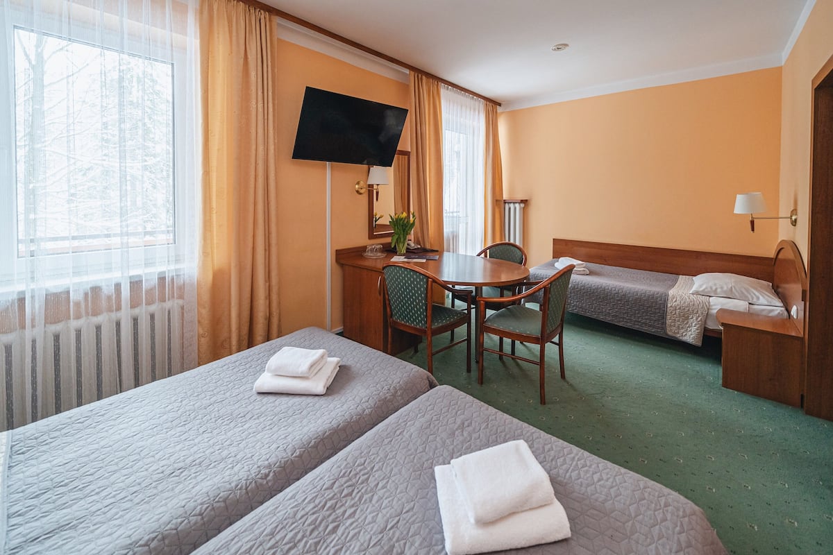 Habitación triple | Escritorio, cunas y ropa de cama
