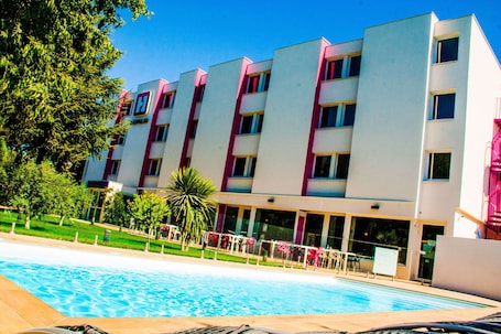 Seasonal outdoor pool, open 9:00 AM to 9:00 PM, pool umbrellas. Best Western Hotelio Montpellier Sud