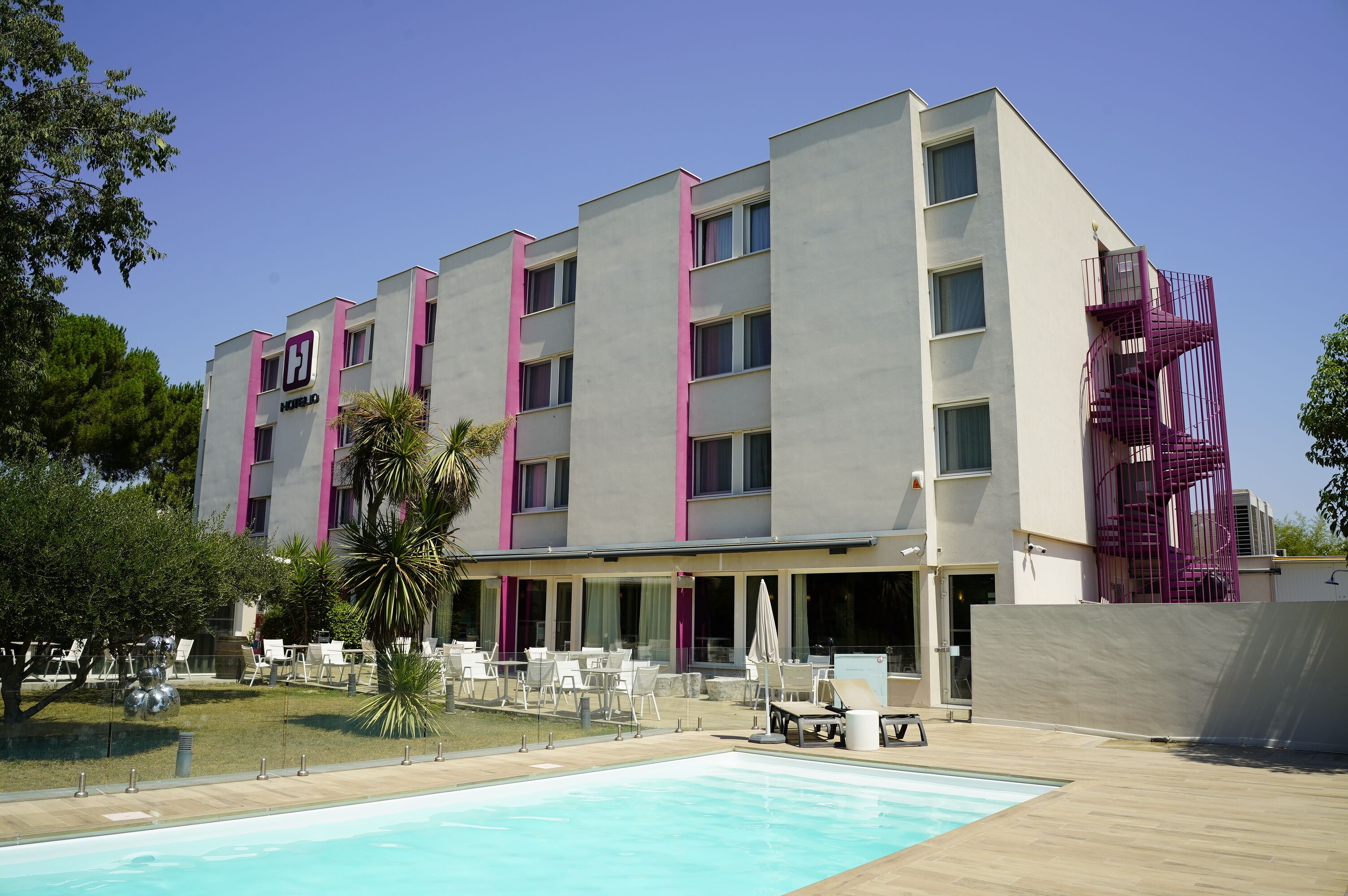 Un hotel con piscina, asientos exteriores y diseño moderno.