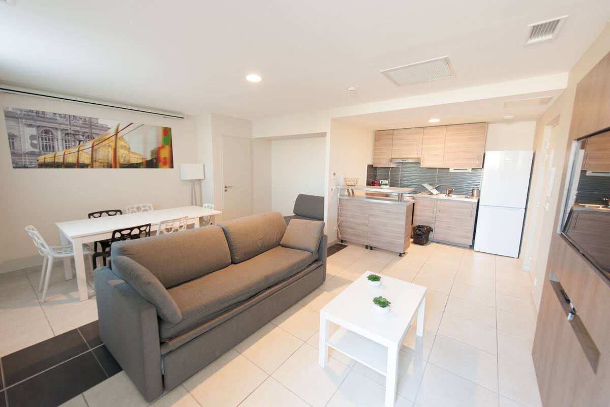 Un apartamento moderno con sala de estar, comedor y cocina.