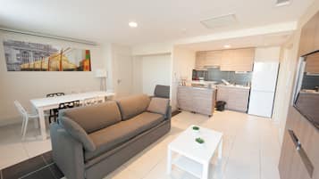 A modern apartment with a living room, dining area, and kitchen.