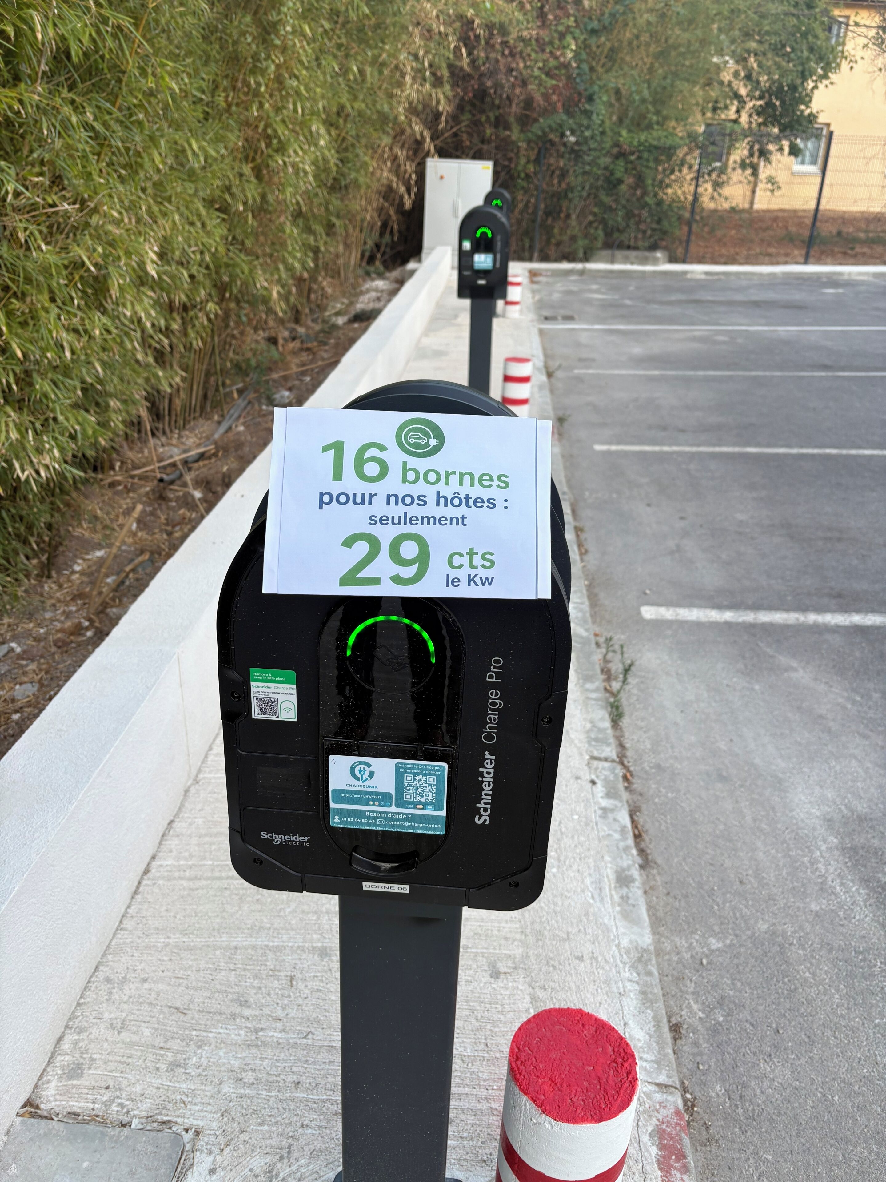 A parking meter with a sign indicating a rate of 29 cents per 16 kWh.